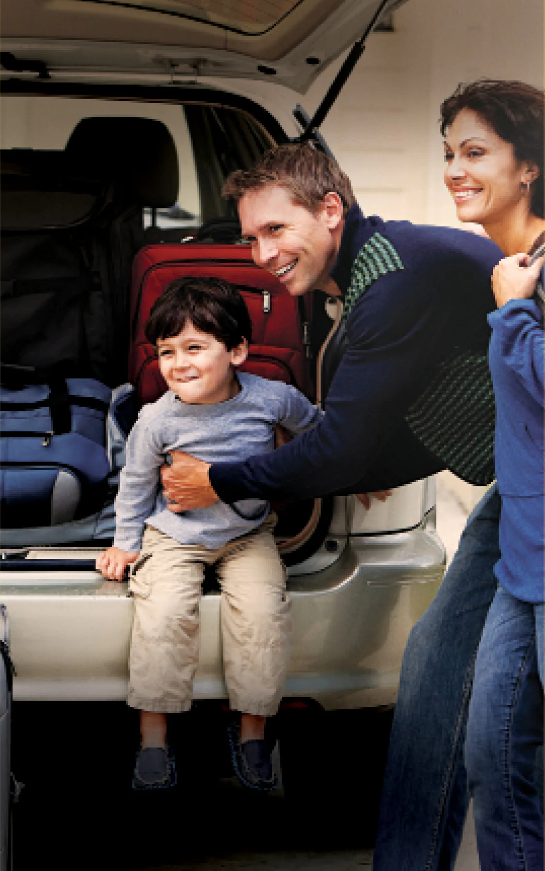 Uma família organizando malas no porta-malas de um carro, preparando-se para uma viagem em conjunto.